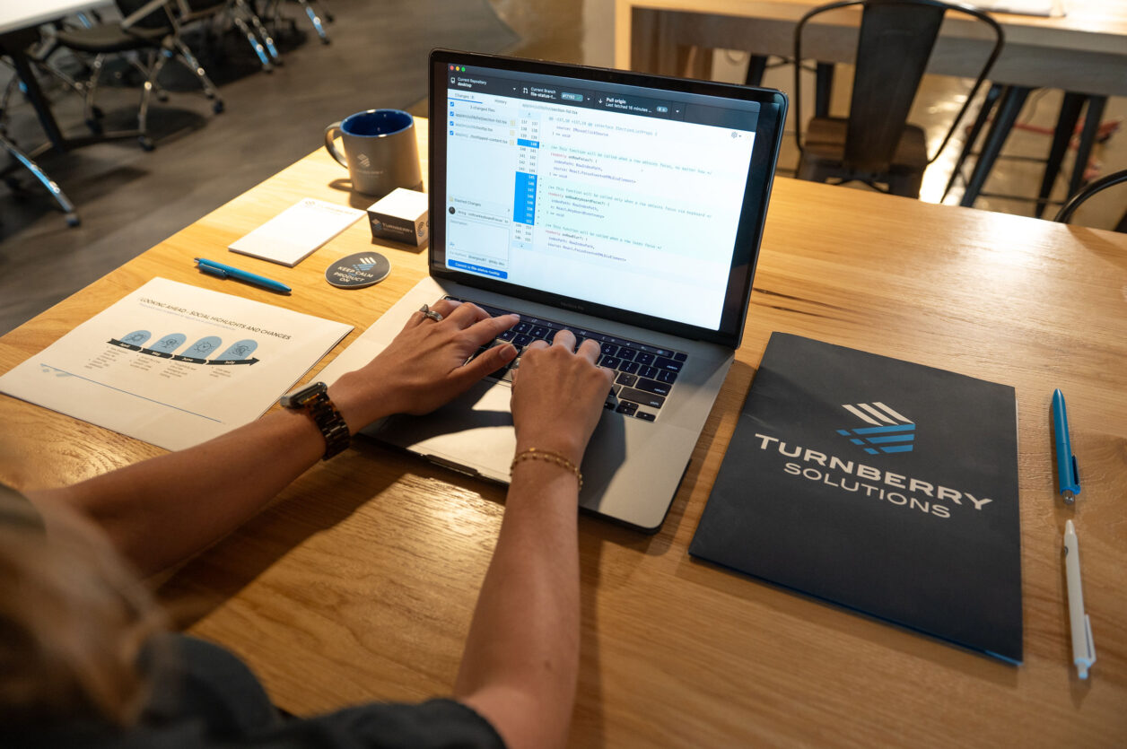 Person working on a laptop with Turnberry Solutions materials